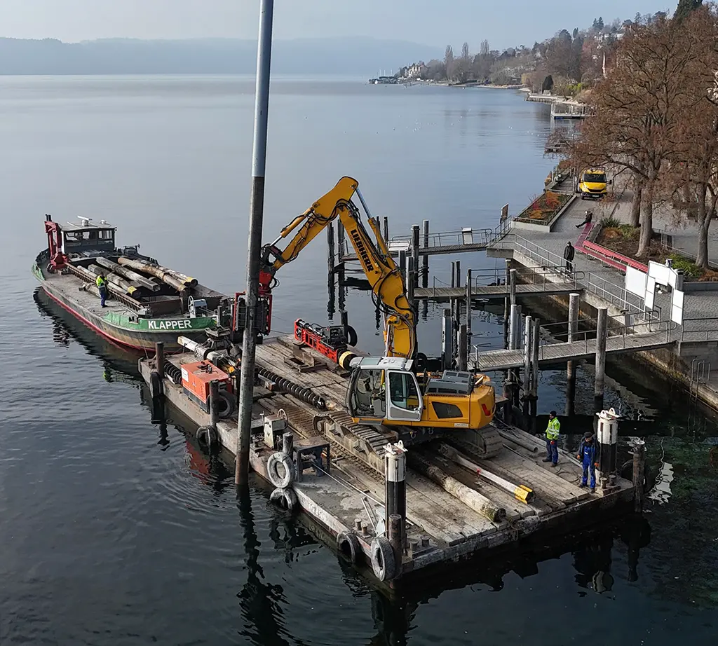 Bagger auf einem Ponton bei Arbeiten am Ufer
