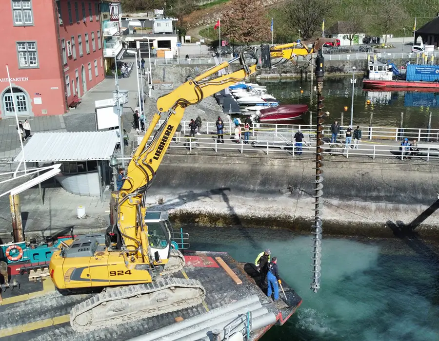 Bagger mit Bohrantrieb auf einem Arbeitsponton im Hafen